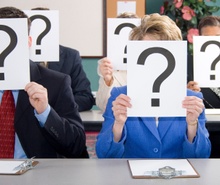 People holding up question marks over their faces